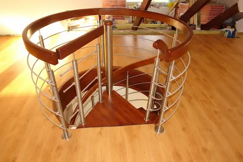Drewniane schody spiralne z metalową balustradą