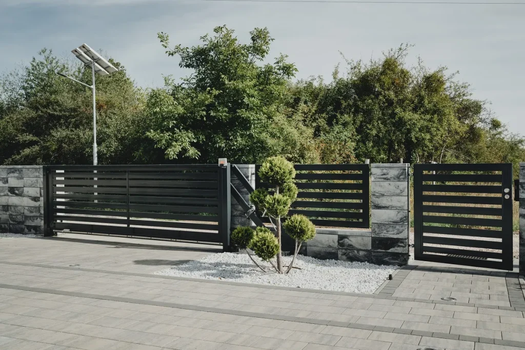 Nowoczesna brama wjazdowa z paneli metalowych.