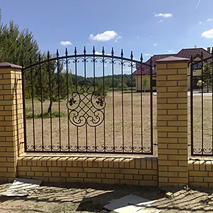 Żelazne ogrodzenie z ceglaną podstawą na wsi