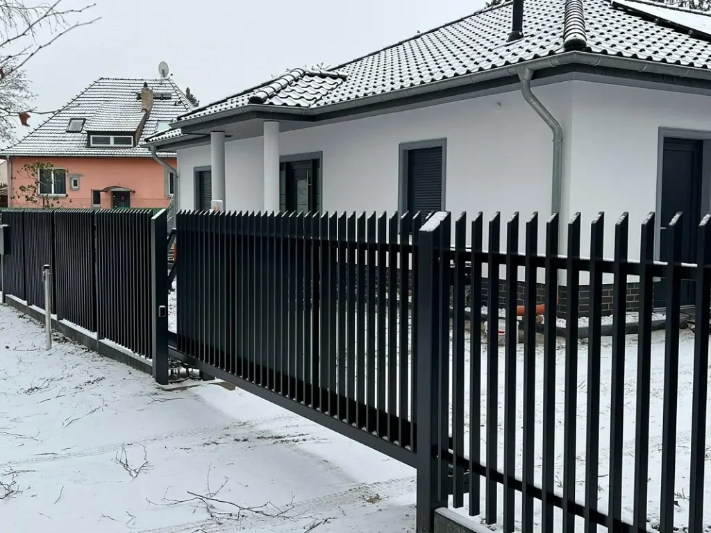 Dom i ogrodzenie w zimowej scenerii.