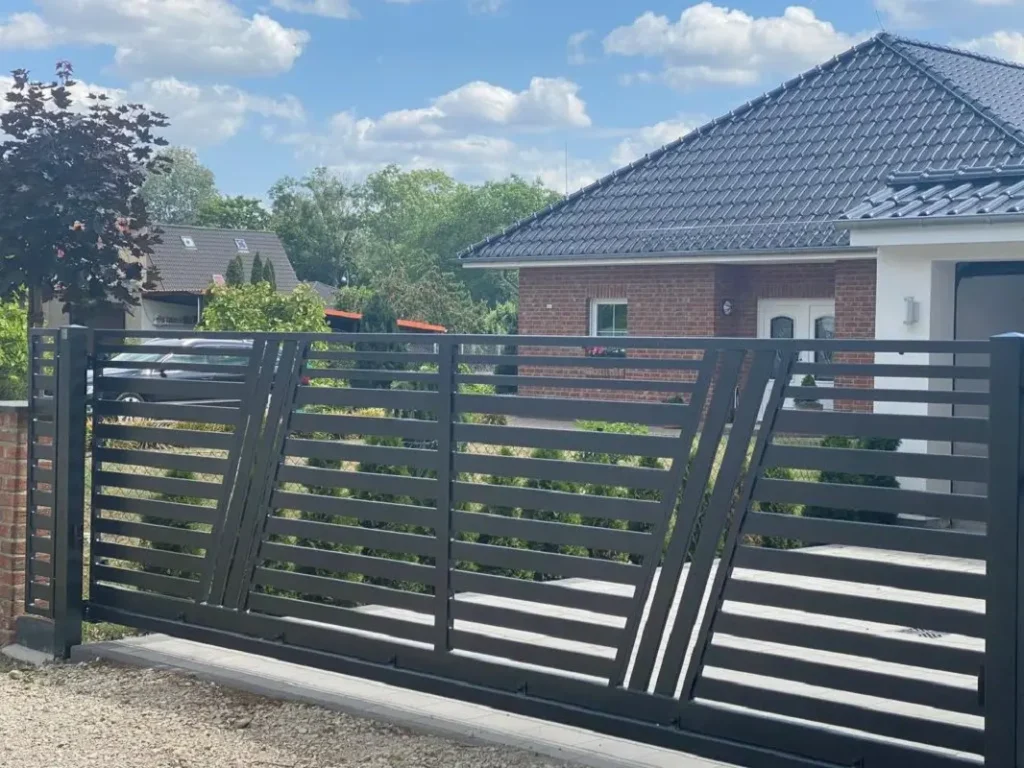 Nowoczesna brama przesuwna przed domem jednorodzinnym.