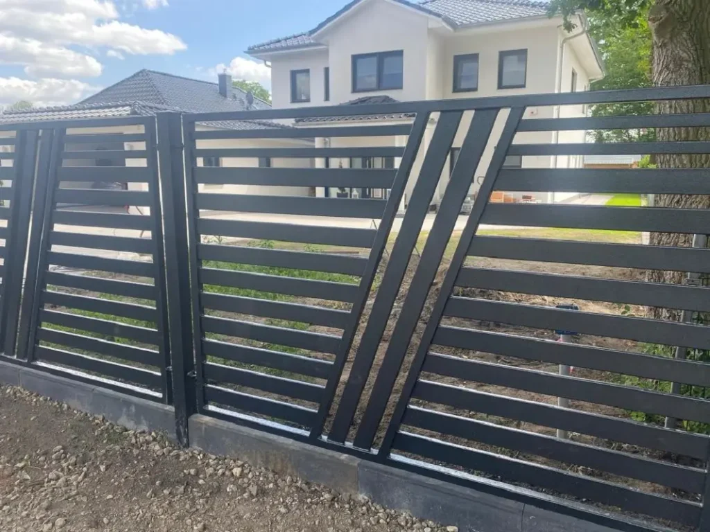 Nowoczesne ogrodzenie metalowe przed domem jednorodzinnym.