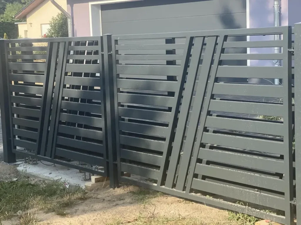 Nowoczesna szara brama ogrodzeniowa przed domem