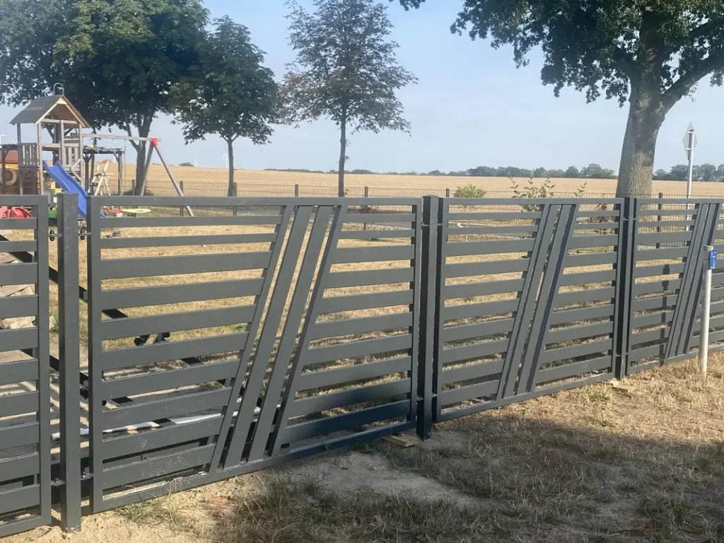 Ogrodzenie z metalu na tle placu zabaw