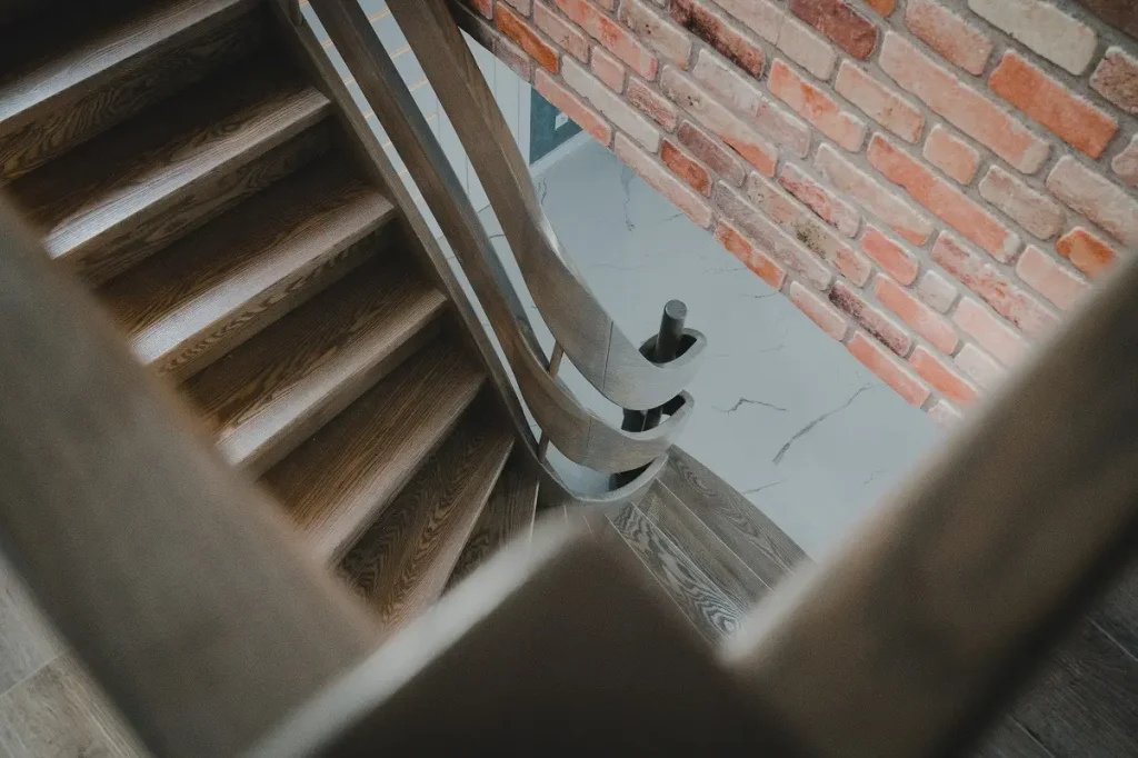 Drewniane schody przy ceglanej ścianie