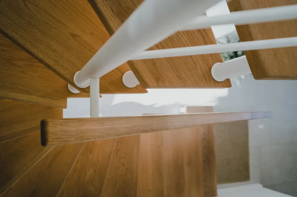 Drewniane schody z białymi balustradami