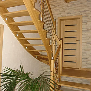 Drewniane schody wewnętrzne z balustradą, roślina doniczkowa.