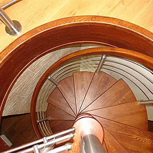 Drewniane schody kręcone z metalową balustradą